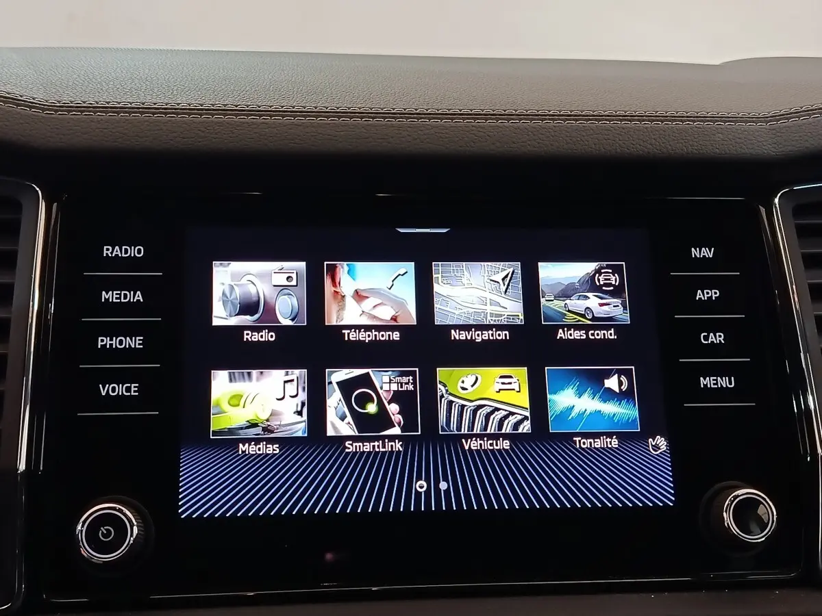 Écran tactile central du tableau de bord du Skoda Kodiaq blanc, affichant les options multimédia et navigation.