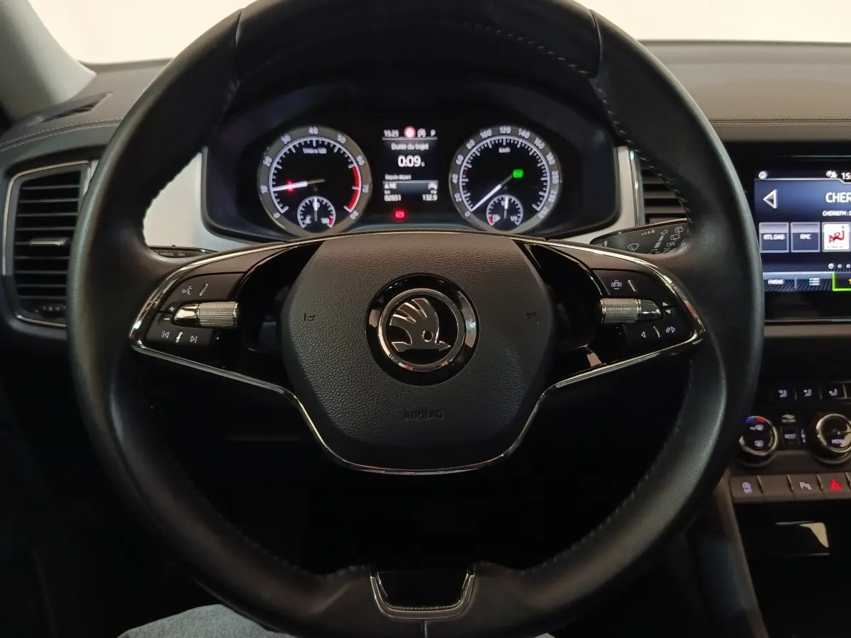 Vue rapprochée du volant noir en cuir du Skoda Kodiaq 2022 avec tableau de bord digital et commandes intégrées.