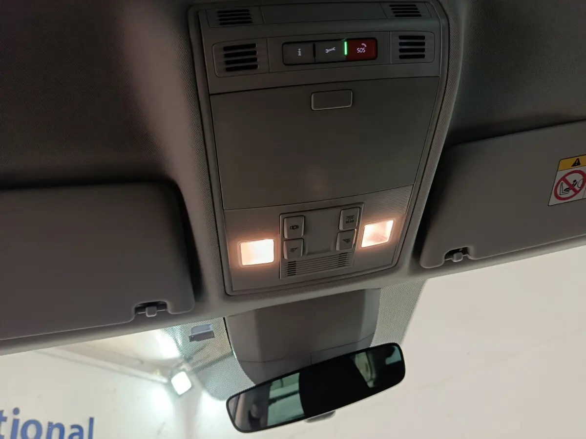 Plafonnier intérieur allumé avec commandes SOS et éclairage, vue centrée vers l'avant du Skoda Kodiaq blanc 2022.