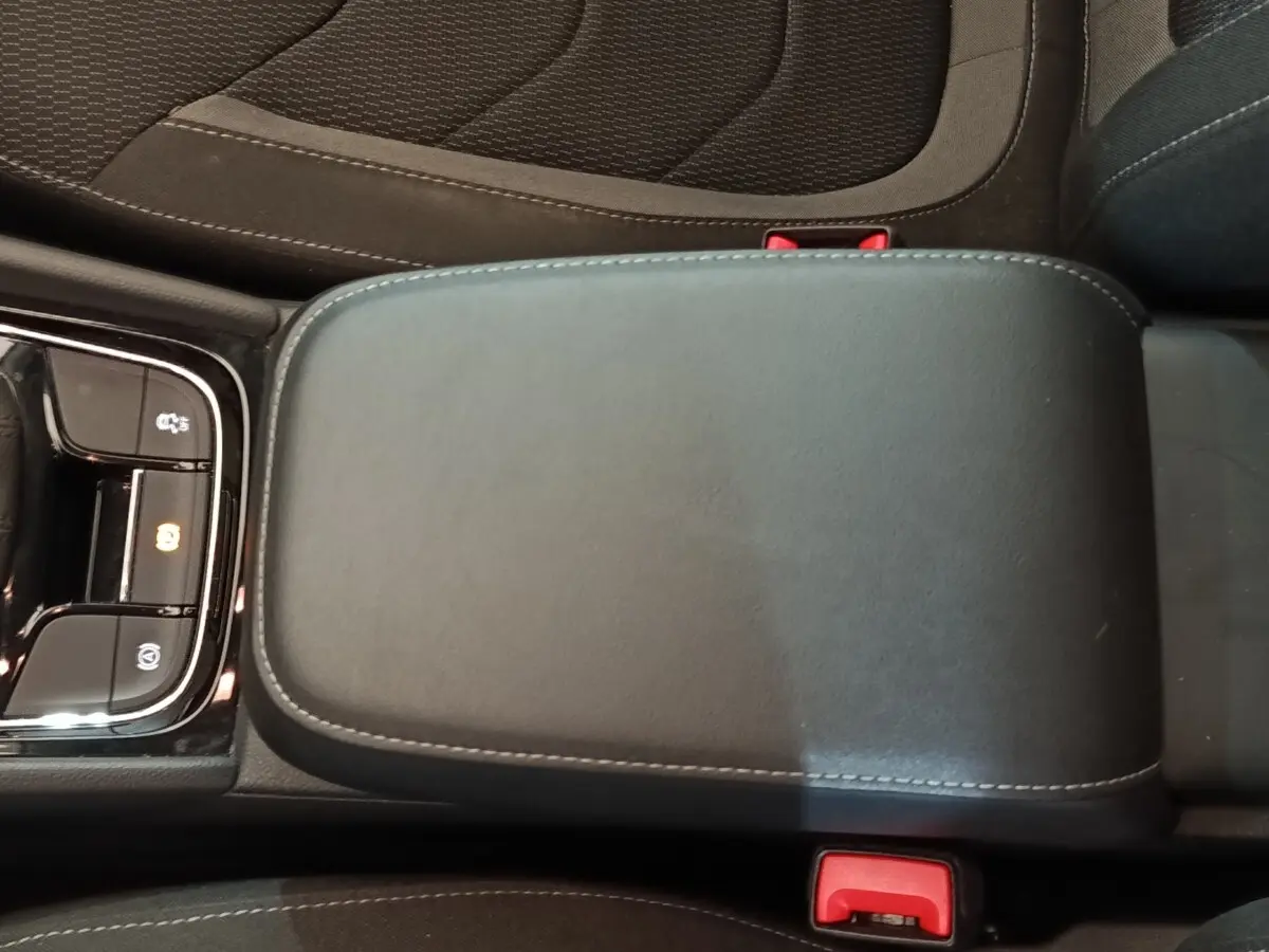 Accoudoir central noir avec coutures grises et commandes électroniques, intérieur du Skoda Kodiaq 2022.