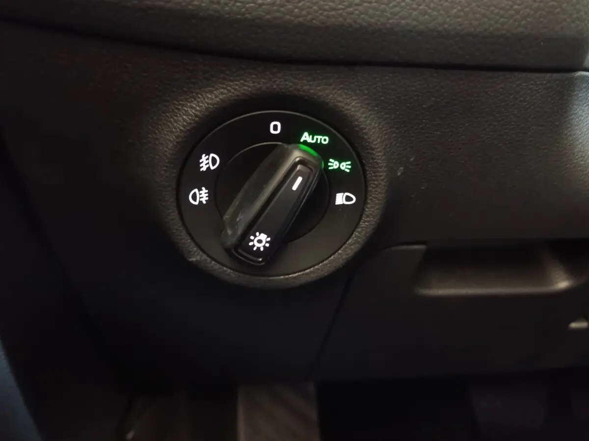 Commande rotative des phares en mode automatique sur tableau de bord noir du Skoda Kodiaq blanc 2022.