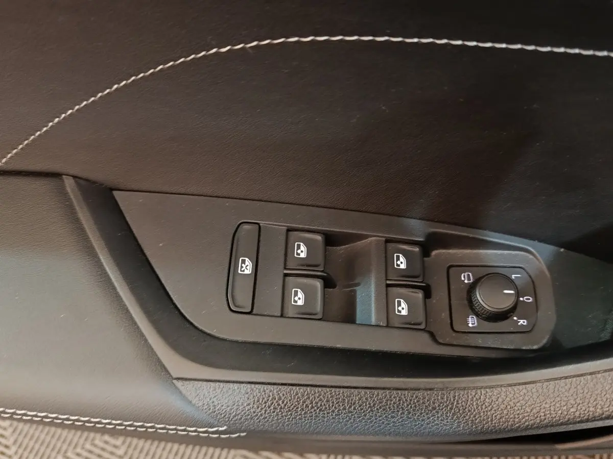 Commande des vitres électriques et réglage des rétroviseurs sur la porte côté conducteur d’un Skoda Kodiaq blanc.