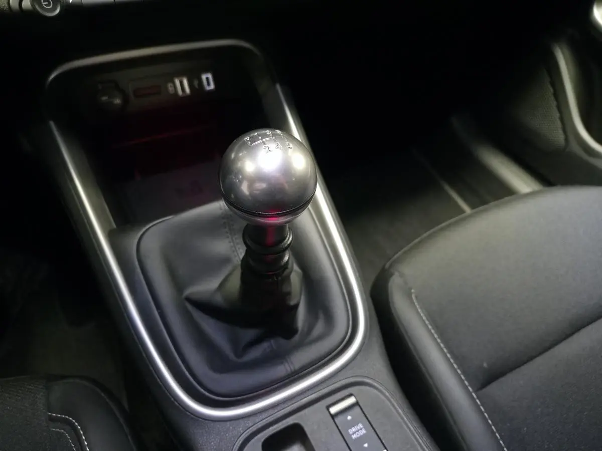 Gros plan sur le levier de vitesses manuel en métal et la console centrale noire du Jeep Avenger 2025.