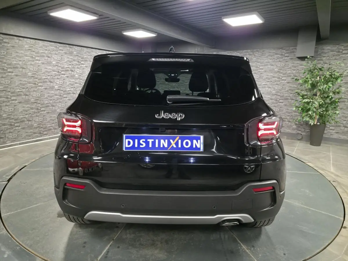 Vue arrière d'un Jeep Avenger noir 2025 avec feux LED allumés et plaque d'immatriculation Distinxion.