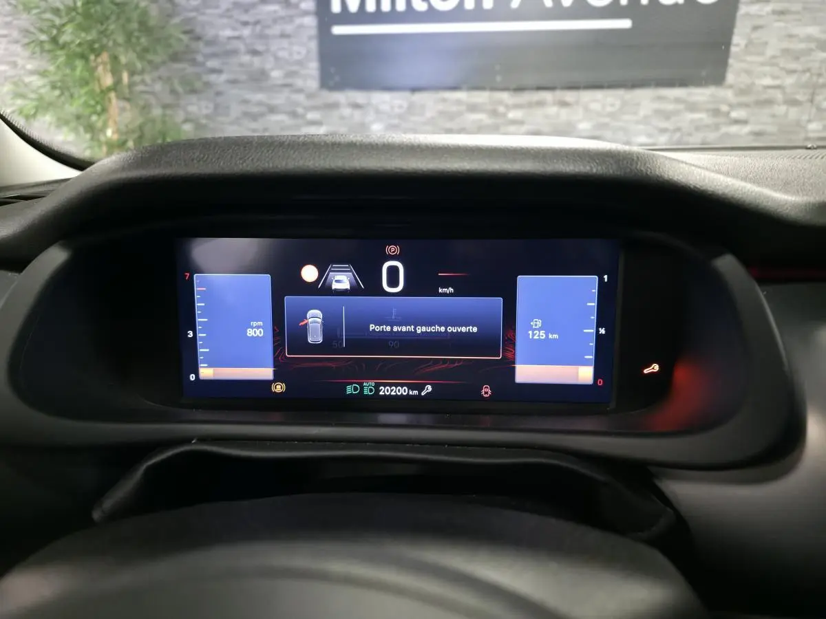 Tableau de bord numérique du Jeep Avenger 2025 affichant une alerte porte avant gauche ouverte.
