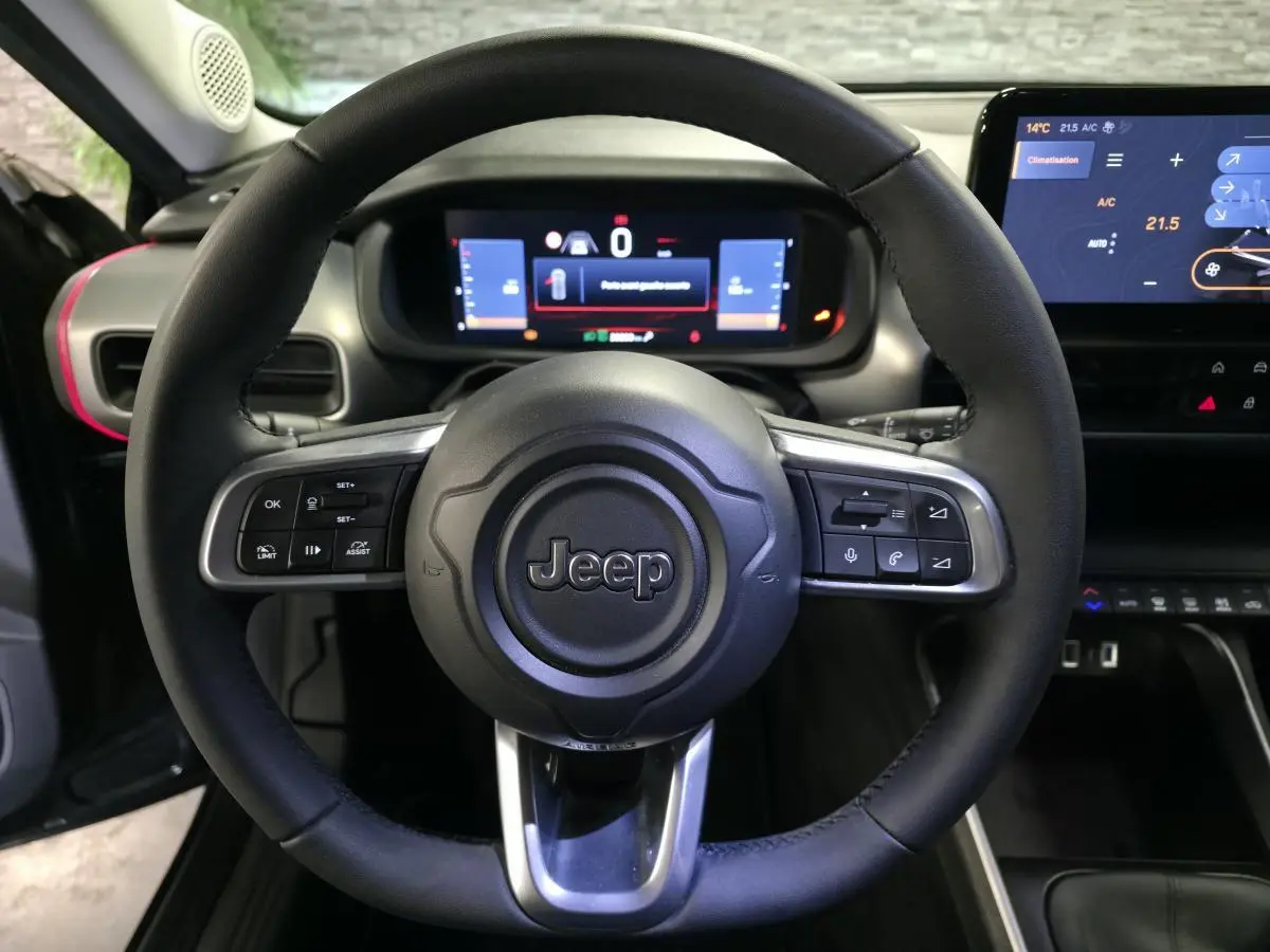 Vue frontale du volant noir Jeep Avenger 2025 avec commandes intégrées et tableau de bord numérique lumineux.