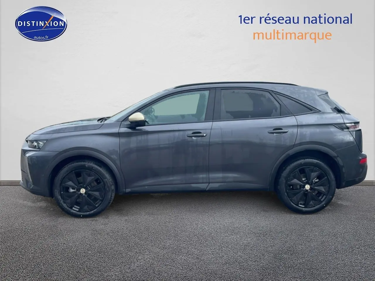 Profil droit du SUV DS7 gris titane avec jantes noires et rétroviseur couleur contrastée beige.