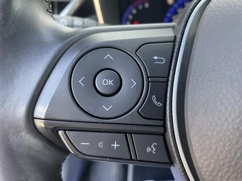 Gros plan sur les commandes multifonctions à gauche du volant de la Toyota Corolla 184 H Collection rouge métal 2019.