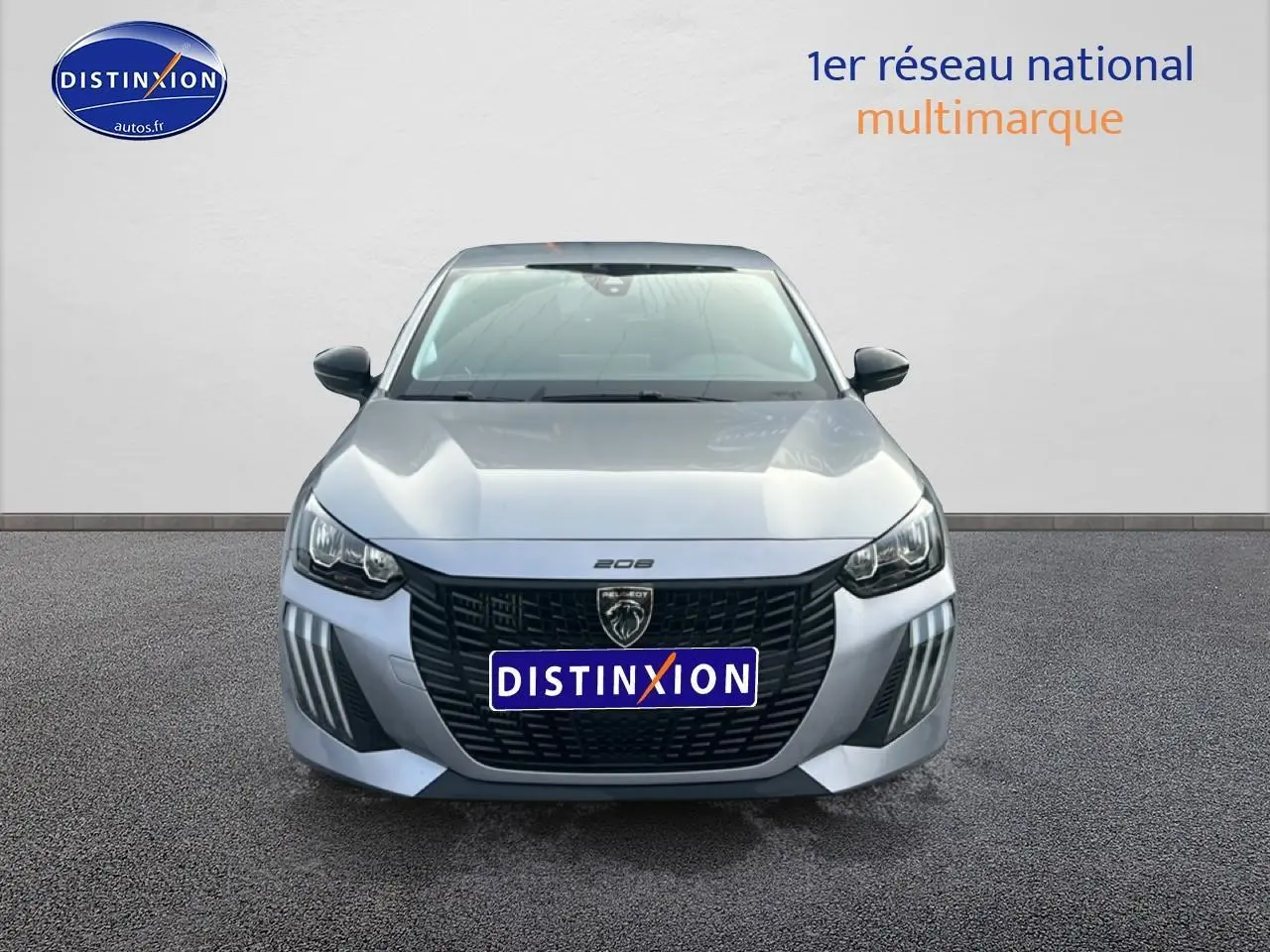 Vue frontale d'une Peugeot 208 1.2 100 Style gris artense avec calandre noire et phares LED distinctifs.