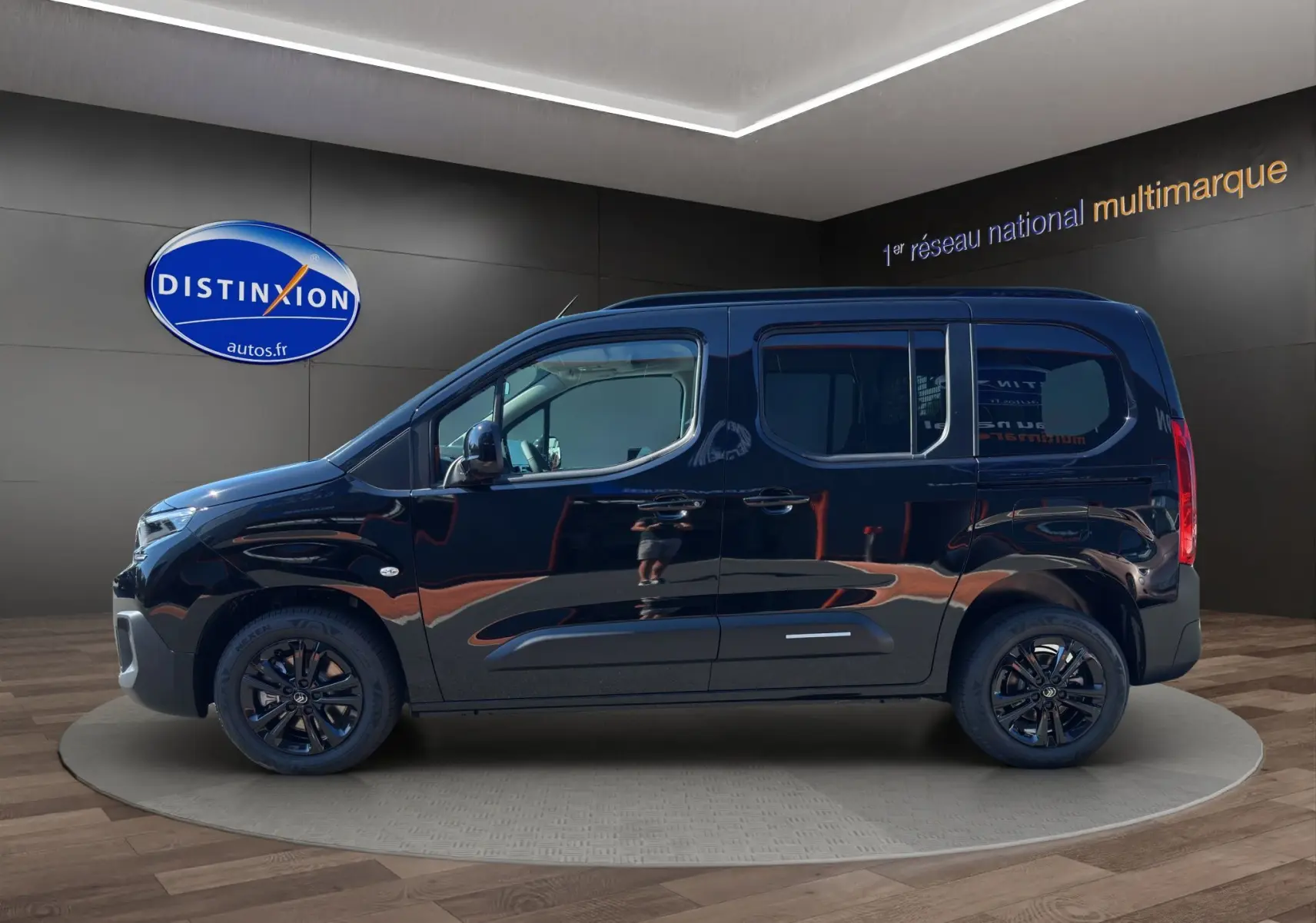 Profil côté gauche d’un Citroën Berlingo noir 2025 avec jantes alliage noires et vitres teintées dans un showroom.