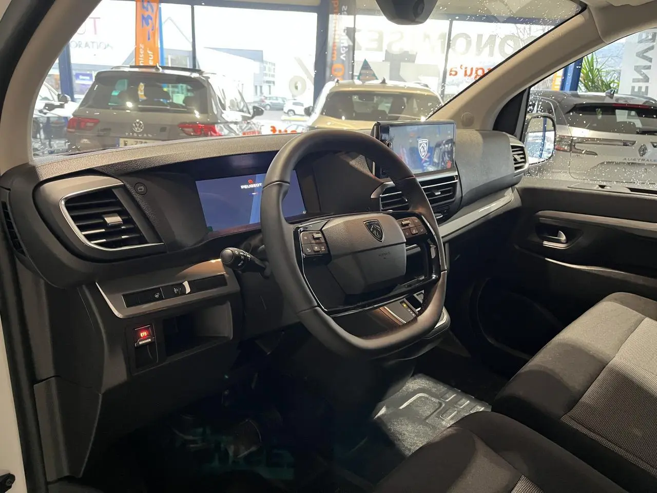 Intérieur du Peugeot Expert Fourgon 2024 vu côté conducteur, volant cuir, tableau de bord numérique et écran tactile.