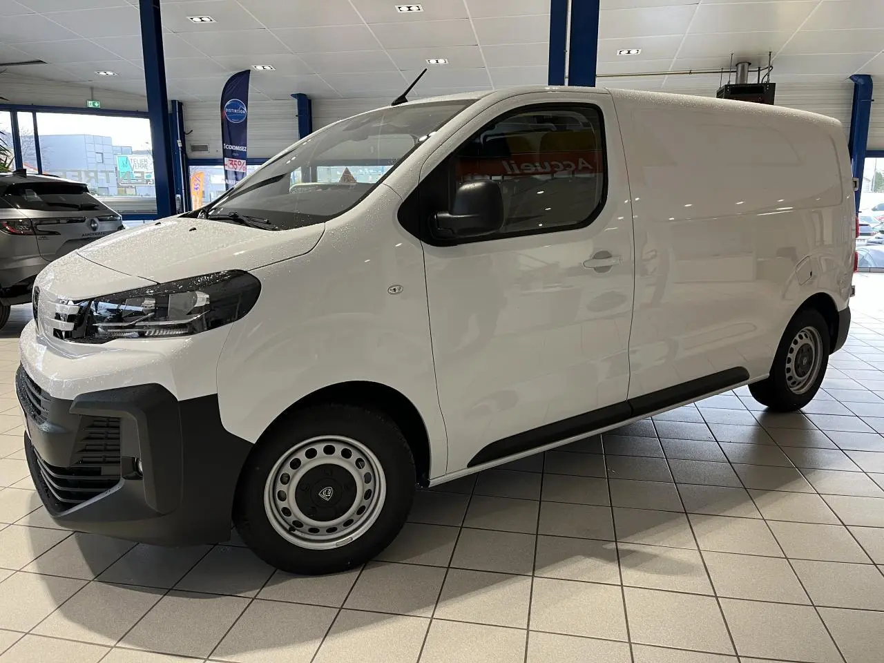 Peugeot Expert Fourgon blanc en vue de profil côté gauche, avec boucliers noirs et roues tôles grises.