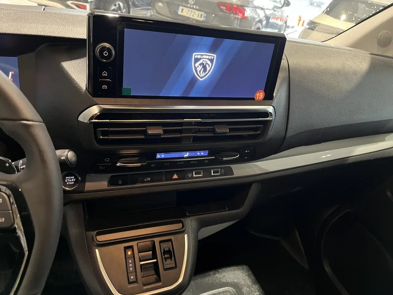 Vue intérieure côté passager du tableau de bord noir et gris du Peugeot Expert Fourgon 2024 avec écran tactile et commandes modernes.