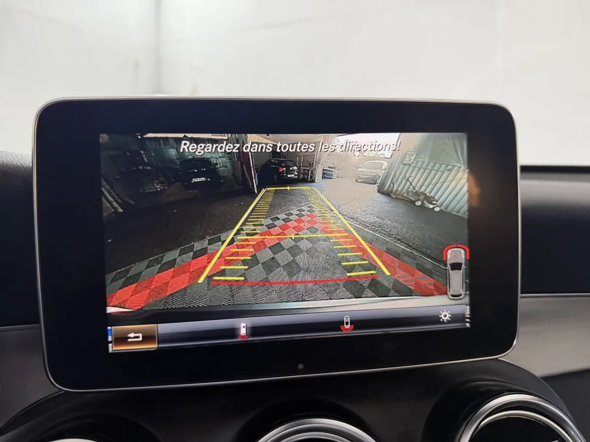 Écran central montrant la caméra de recul avec guidage de trajectoire dans un Mercedes GLC 250 gris foncé.
