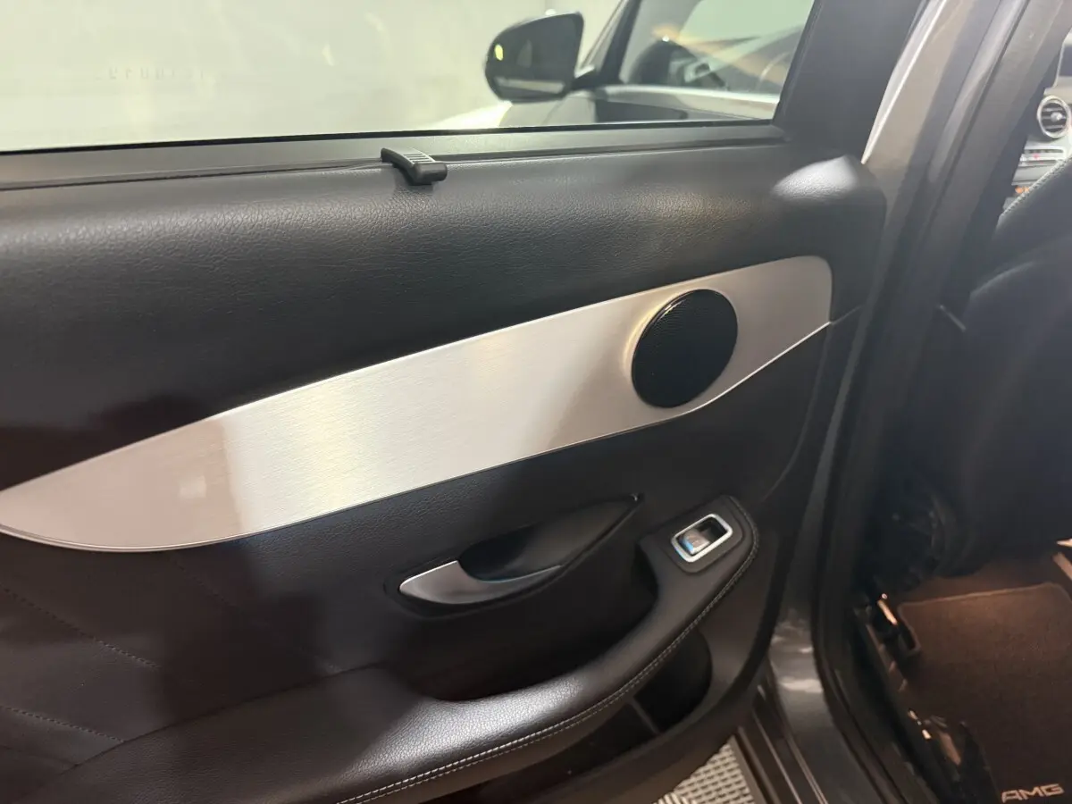 Détail de la porte arrière gauche intérieure du Mercedes GLC 250 Fascination 2019 avec garniture noire et insert aluminium.