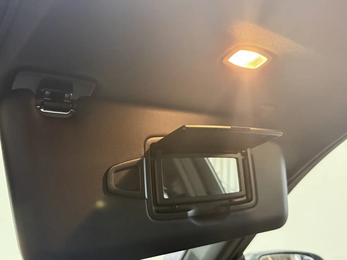 Détail du pare-soleil côté conducteur avec miroir éclairé dans un Mercedes GLC 250 Fascination gris foncé, vue intérieure.