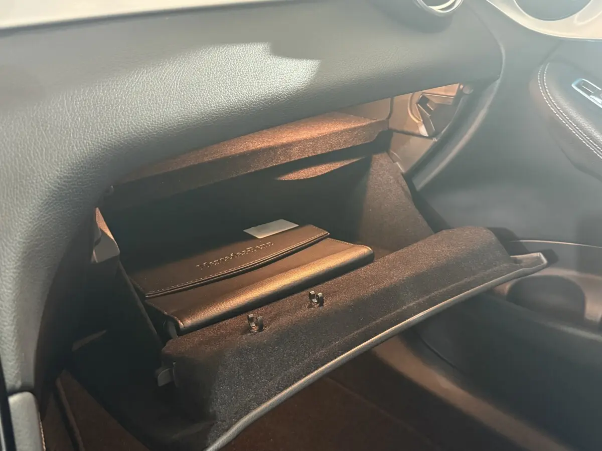 Gros plan de la boîte à gants ouverte côté passager dans l’habitacle noir d’un Mercedes GLC 250 Fascination 2019.