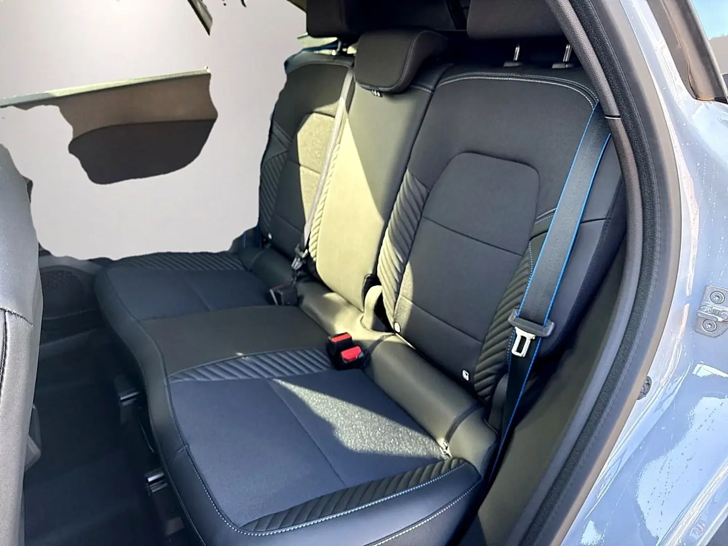 Vue côté droit de la banquette arrière noire avec surpiqûres bleues du Renault Symbioz gris rafale 2026.