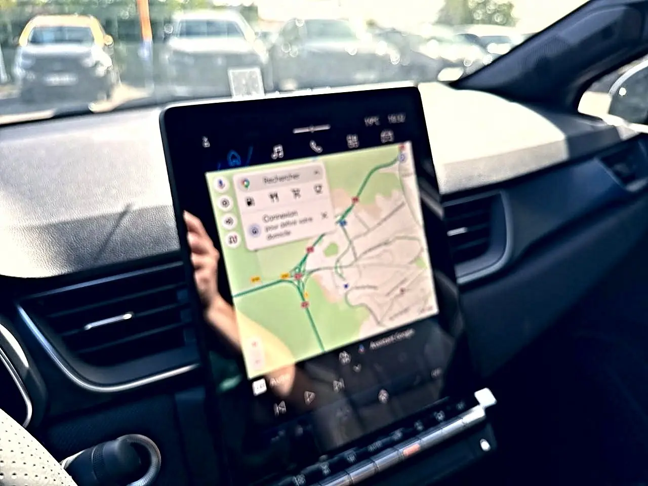 Vue intérieure du tableau de bord du Renault Symbioz gris rafale, avec écran tactile affichant une carte GPS.