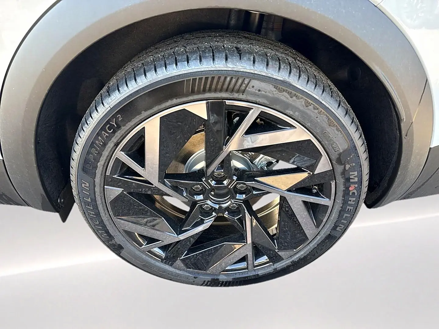 Gros plan sur la roue avant droite du Renault Symbioz gris rafale, jante alu noire au design géométrique.