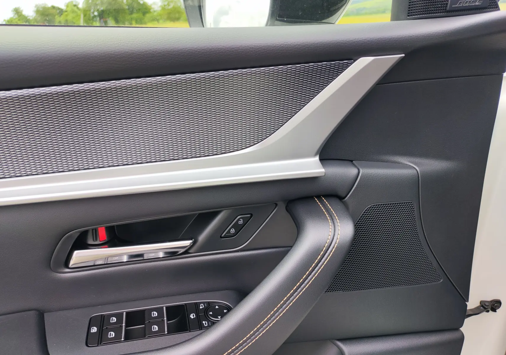 Détail de la porte côté gauche du Mazda CX-60 blanc métal 2024 avec commandes électriques et haut-parleur Bose intégré.