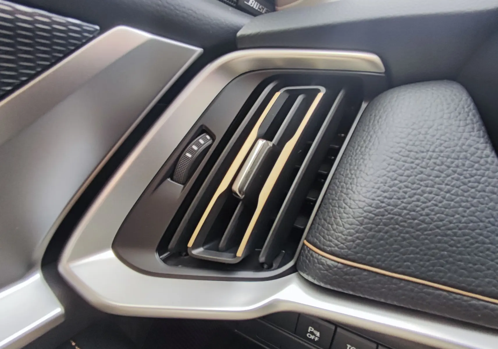 Détail de la sortie d'air côté gauche avec insert bois et cuir noir sur tableau de bord du Mazda CX-60 blanc métal 2024.