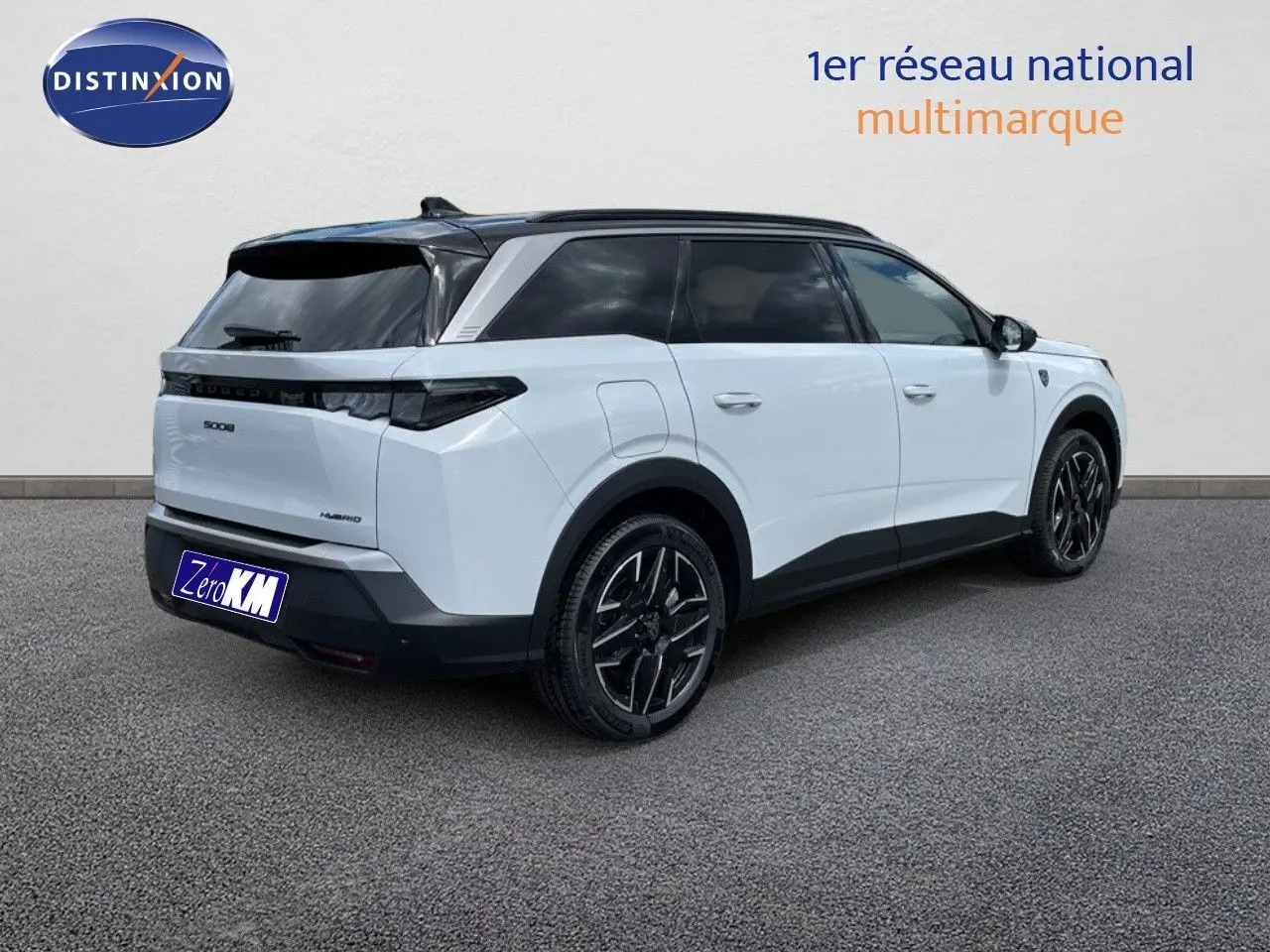 Peugeot 5008 Hybrid 136ch GT blanc Okenite métal avec toit noir, vue 3/4 arrière côté droit sur sol gris.