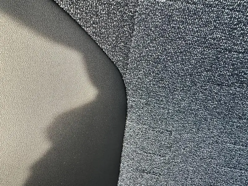 Gros plan sur le tissu CRISPY gris et cuir noir du siège avant du Peugeot 3008 Hybrid 2025.