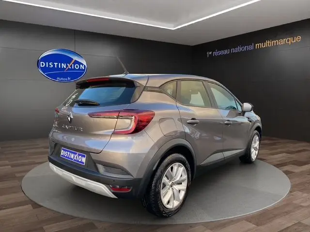 Vue 3/4 arrière droit d'un Renault Captur TCE 90 Équilibre gris Cassiopée dans un showroom Distinxion.