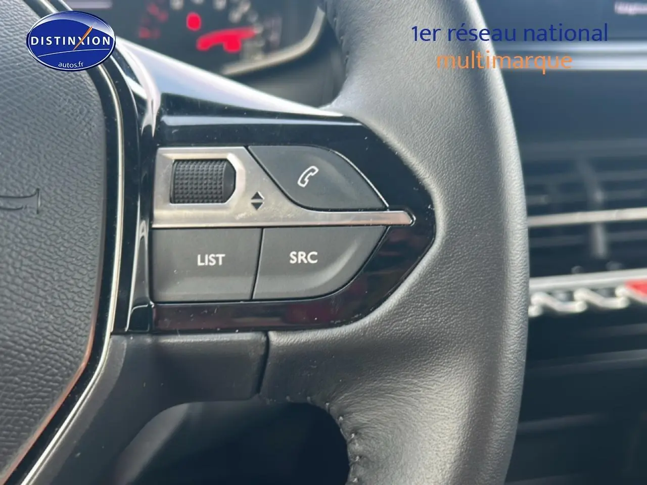 Gros plan sur les commandes audio au volant en cuir noir du Peugeot 208 1.2 100 style, intérieur moderne et épuré.