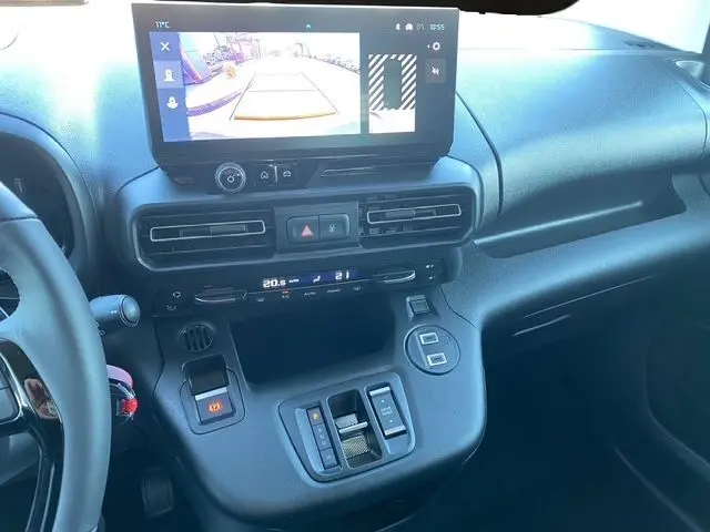 Vue intérieure du tableau de bord du Citroën Berlingo gris, avec écran tactile affichant la caméra de recul et commandes de climatisation.