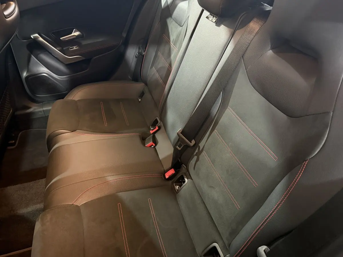 Vue intérieure côté droit montrant la banquette arrière en cuir noir avec surpiqûres rouges de la Mercedes Classe A A 200 AMG Line.