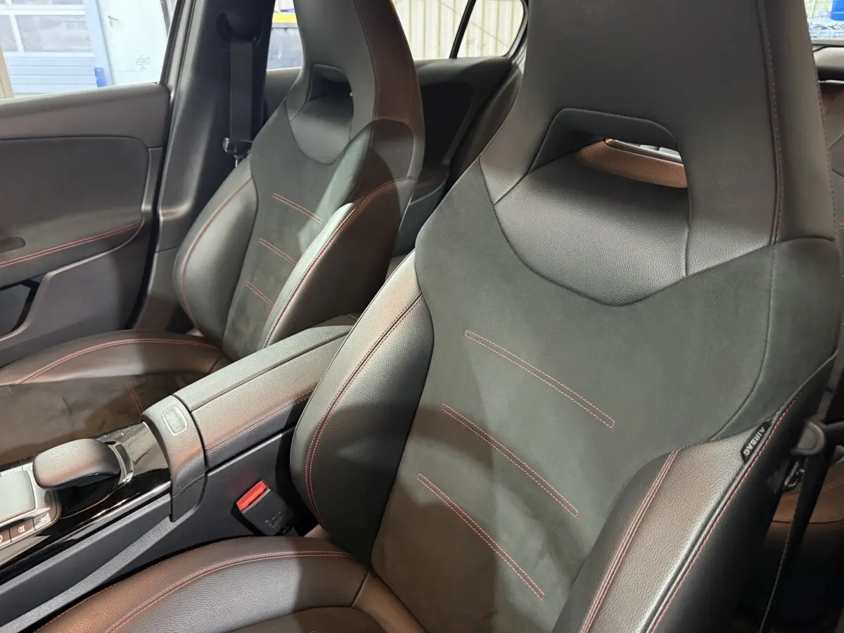 Vue rapprochée des sièges avant en cuir noir avec surpiqûres rouges dans l’habitacle d’une Mercedes Classe A AMG Line 2021.