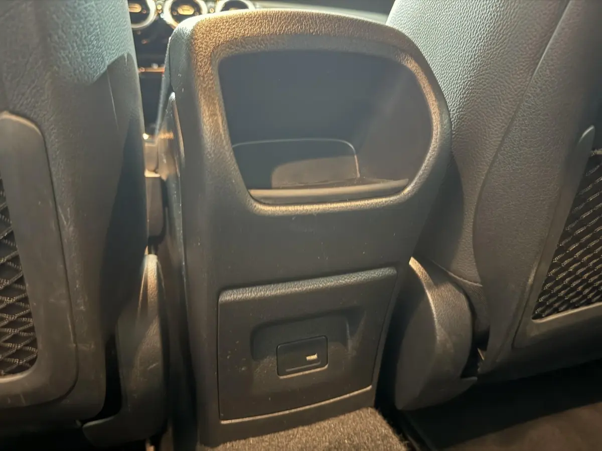 Prise USB arrière noire vue entre les sièges avant d’une Mercedes Classe A 200 AMG Line gris foncé.