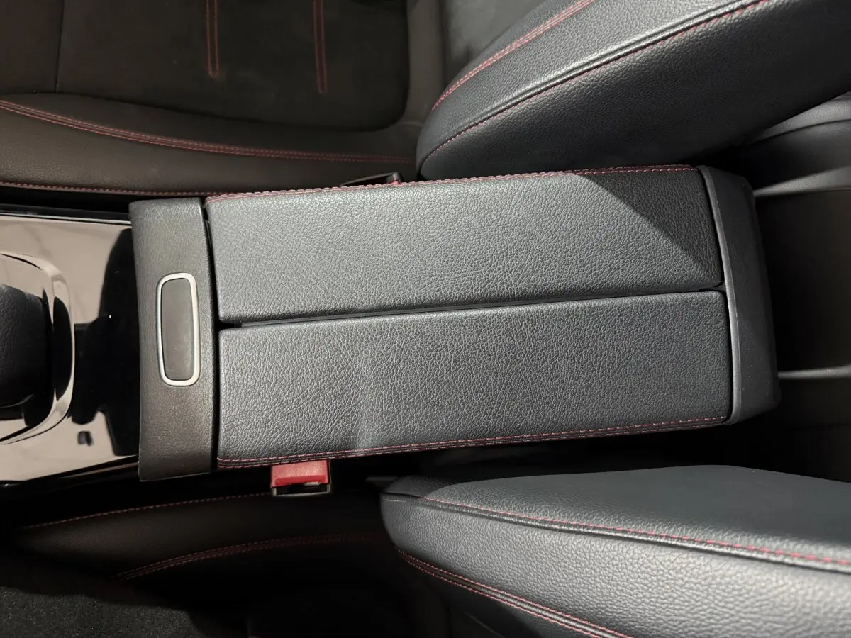 Gros plan sur l'accoudoir central en cuir noir avec surpiqûres rouges dans une Mercedes Classe A A 200 AMG Line 2021.