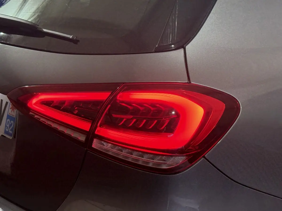 Gros plan sur le feu arrière droit rouge d’une Mercedes Classe A A 200 AMG Line gris foncé, vue arrière côté droit.