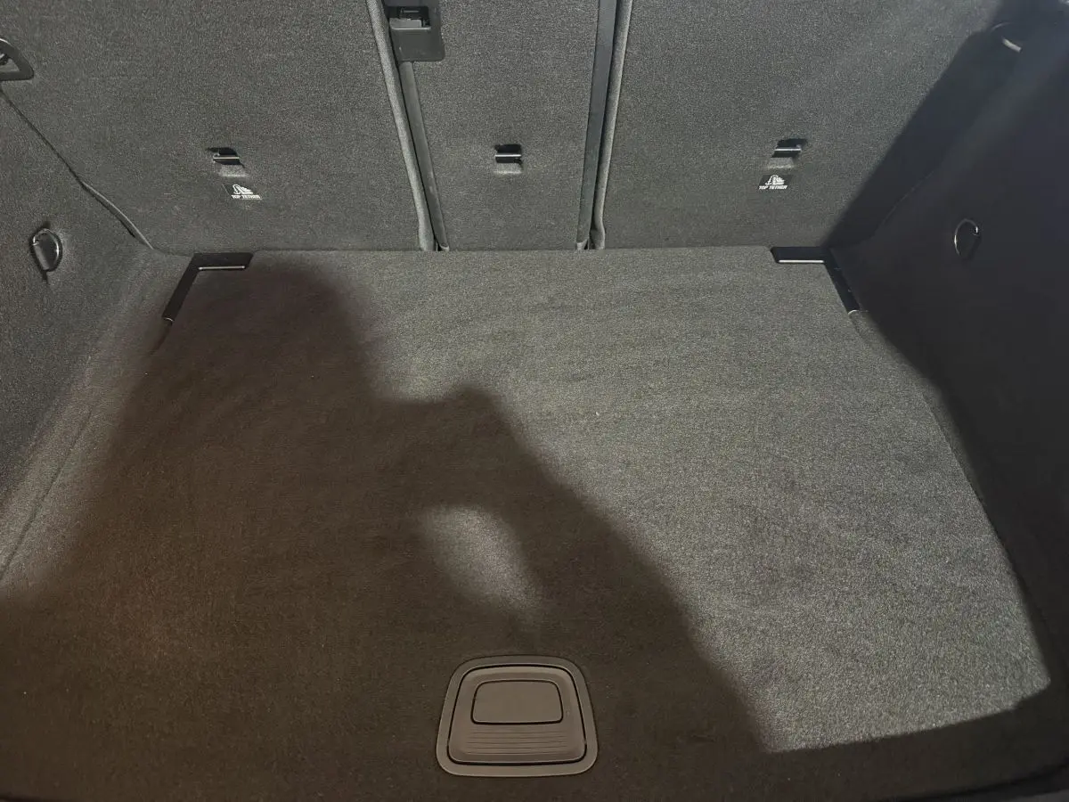 Vue intérieure du coffre spacieux et propre de la Mercedes Classe A A 200 AMG Line 2021, revêtement gris foncé.