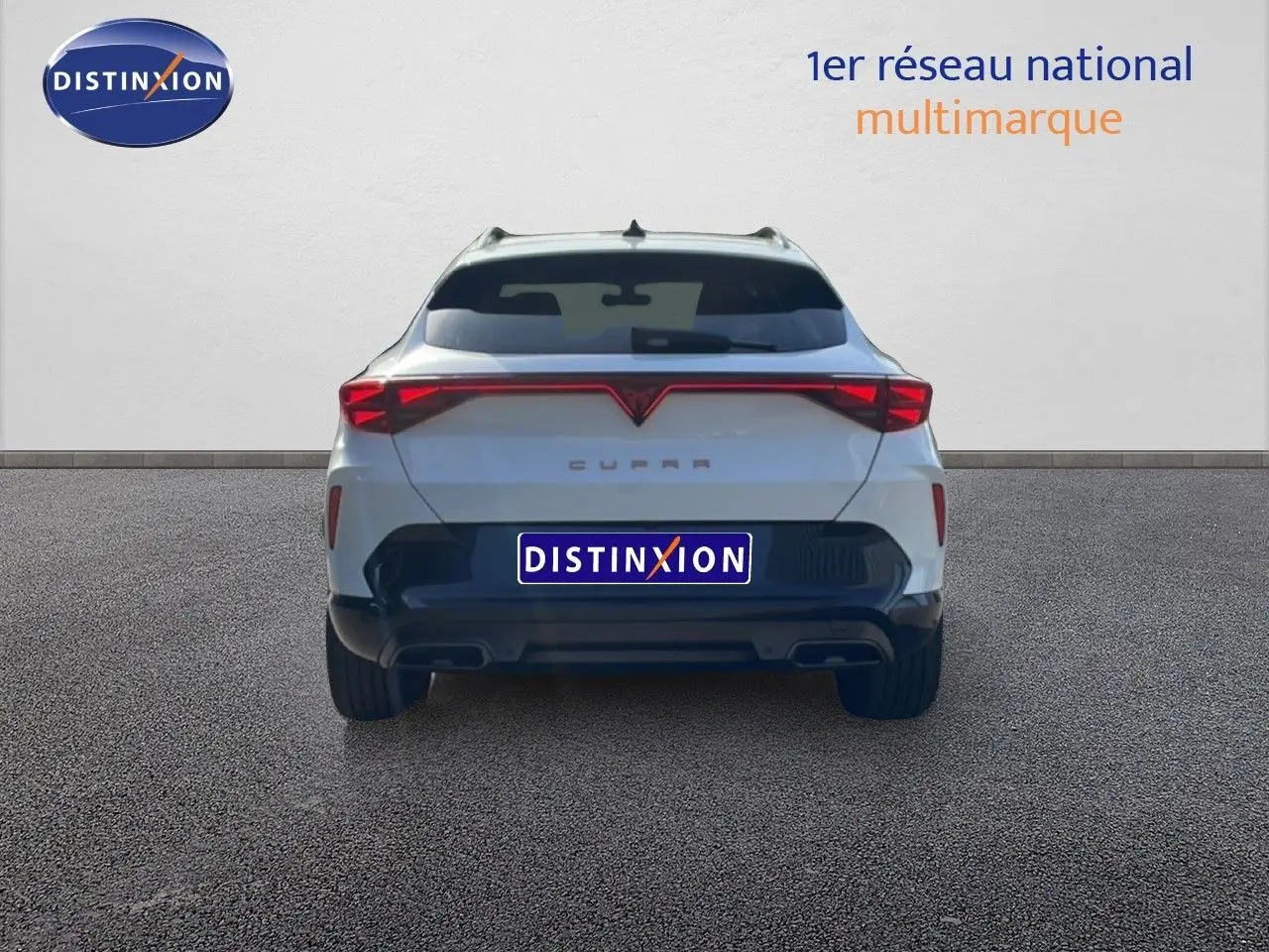 Vue arrière d'un CUPRA Formentor blanc neige métal 2025 avec feux arrière LED et double sortie d'échappement.