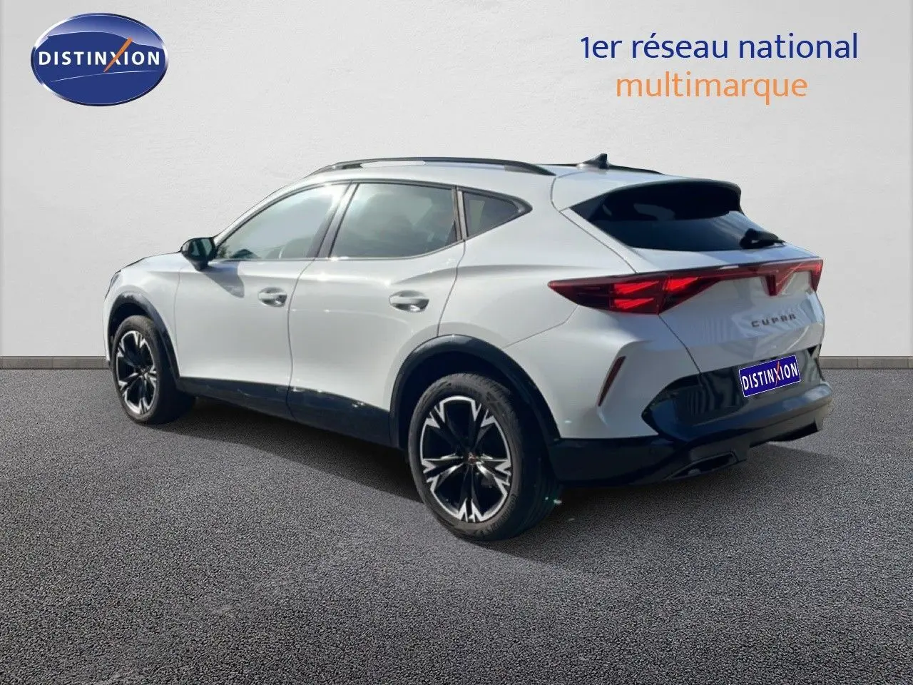Vue 3/4 arrière droite du CUPRA Formentor blanc neige métal avec jantes noires bicolores et feux arrière LED.