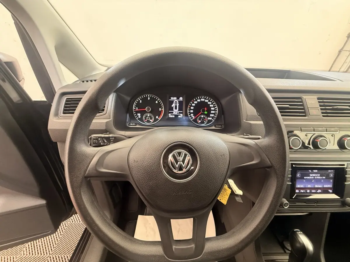 Vue intérieure centrée sur le volant noir Volkswagen Caddy 2019 avec tableau de bord et écran tactile visibles.