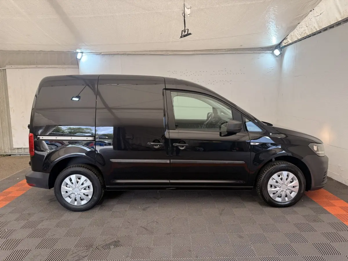 Volkswagen Caddy noir 2019 vue de profil côté gauche, fourgon utilitaire avec jantes acier et portes latérales.