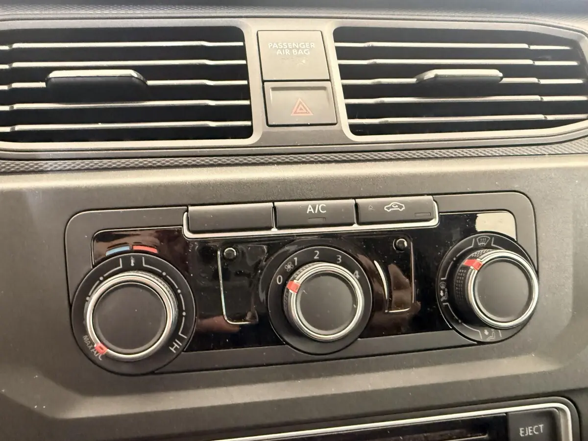 Gros plan sur les commandes de climatisation du tableau de bord du Volkswagen Caddy noir 2019.
