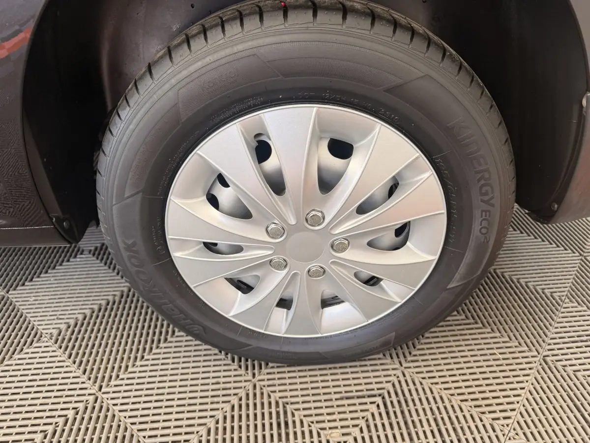 Gros plan sur la roue avant droite du Volkswagen Caddy noir avec enjoliveur argenté et pneu Hankook.