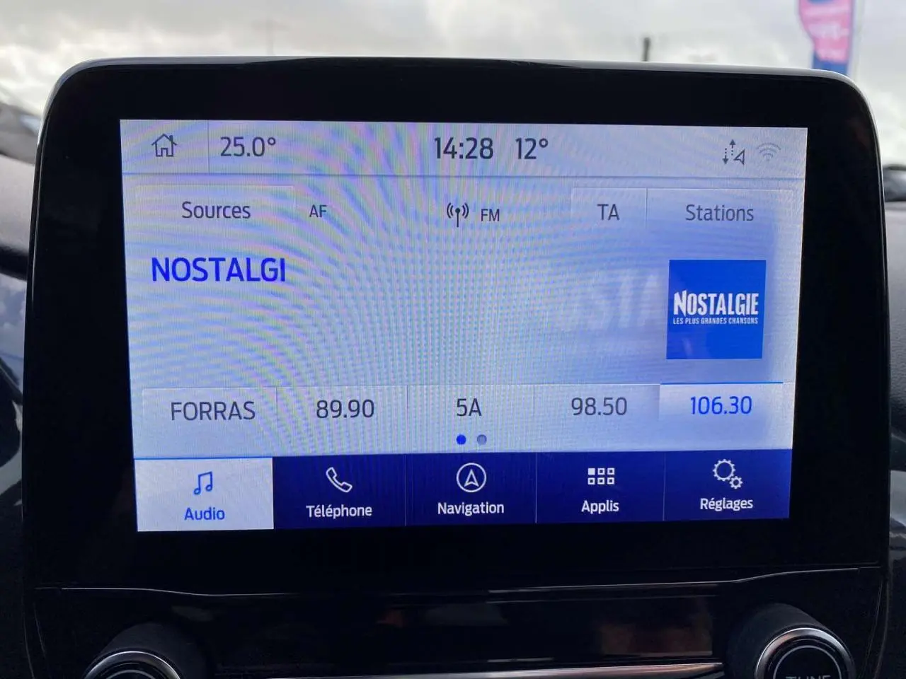 Écran tactile central du Ford Puma rouge Fantastic 2022 affichant la radio Nostalgie à 14h28