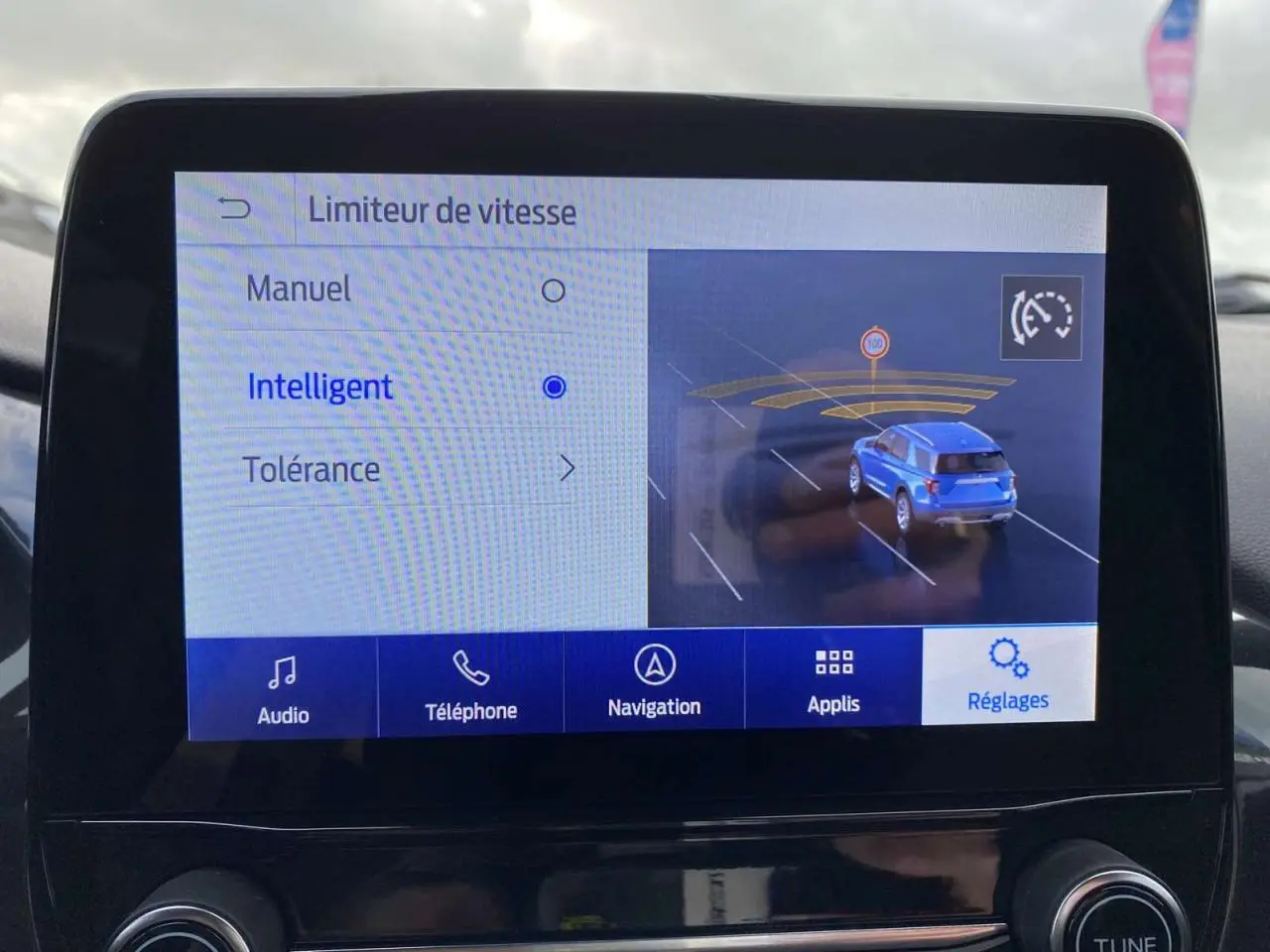Écran tactile intérieur montrant le réglage du limiteur de vitesse intelligent sur une Ford Puma rouge.