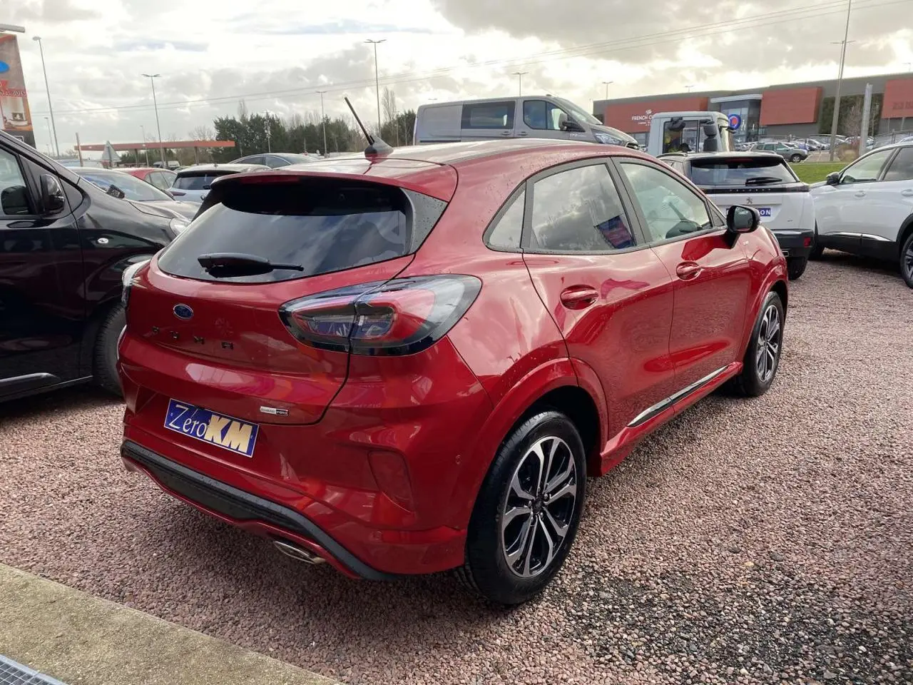 Vue 3/4 arrière droite d'un Ford Puma rouge Fantastic avec jantes alliage noires et badges ST-Line visibles.