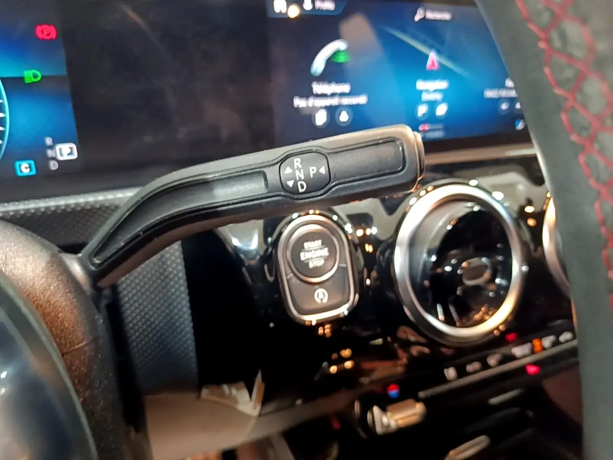 Gros plan intérieur sur la commande de boîte automatique et le bouton start/stop de la Mercedes Classe A noire AMG Line.