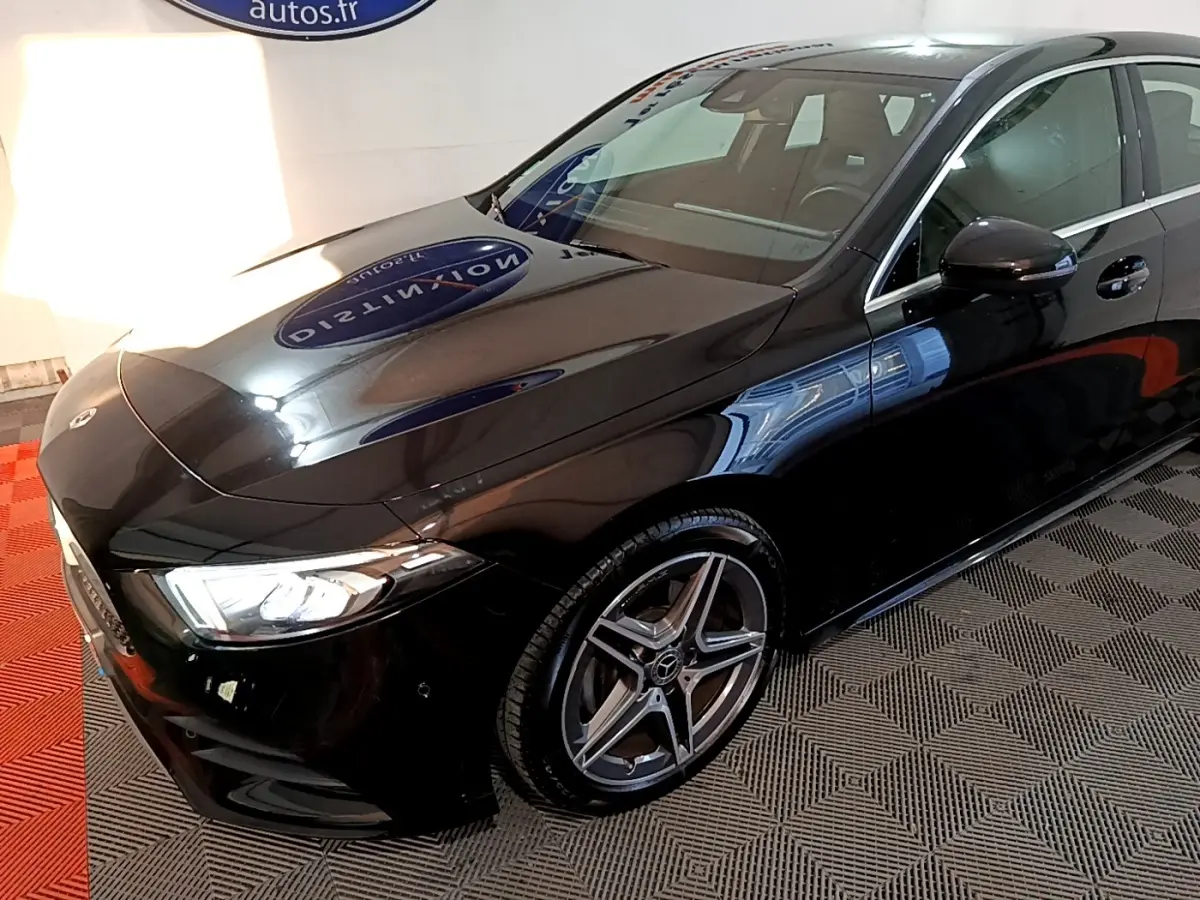 Mercedes Classe A 200 AMG Line noire vue 3/4 avant droit, mettant en valeur ses jantes alliage et phares LED distinctifs.