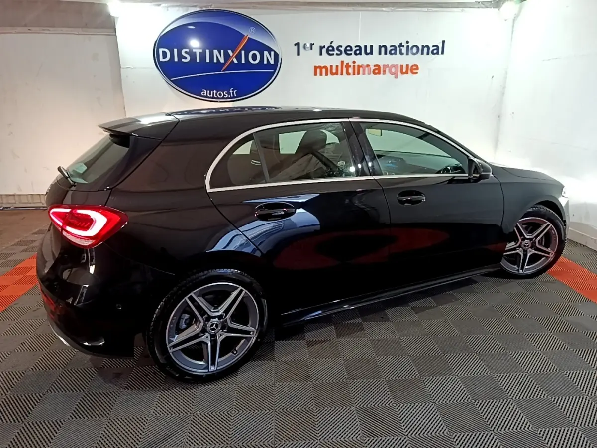 Vue 3/4 arrière droite d'une Mercedes Classe A 200 AMG Line noire, avec jantes alliage et feux LED allumés.