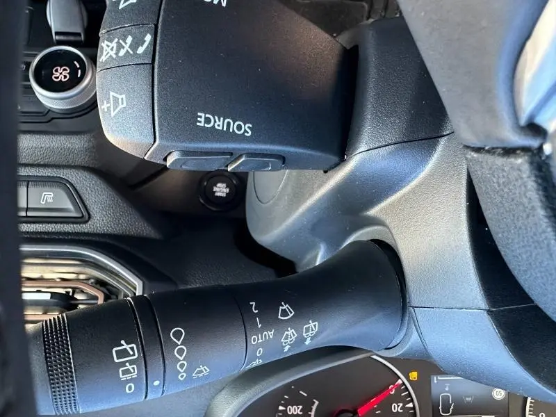 Gros plan sur la commande de l’essuie-glace et le commodo multifonction noir dans l’habitacle du Dacia Jogger noir nacré.